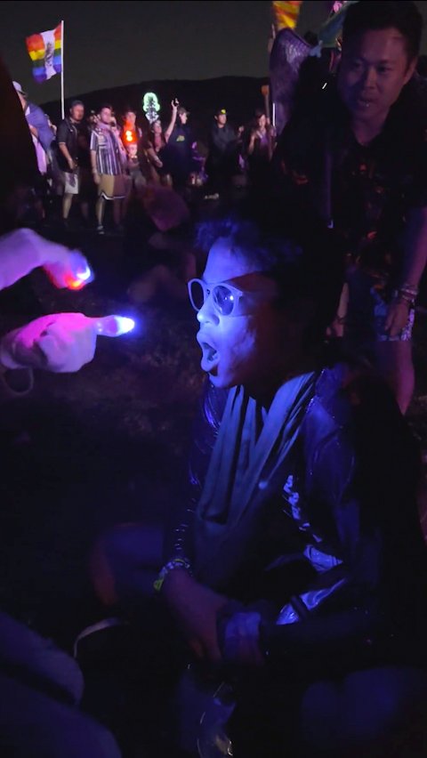 Glover reaching toward a smiling festival-goer at an outdoor show